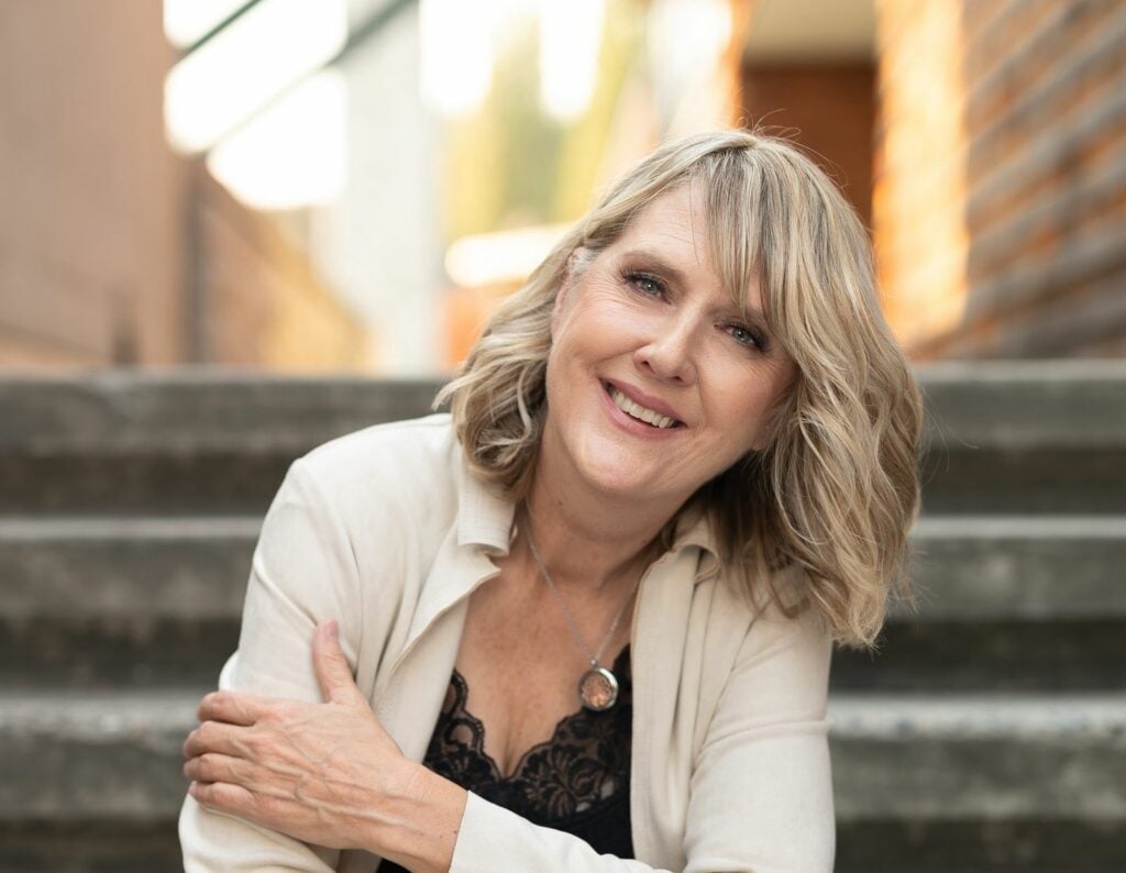 mid-age woman sitting on the stairs smiling