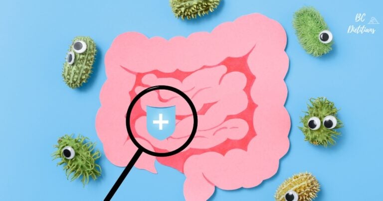 magnifying glass placed on the intestine, with gut microbiome around it